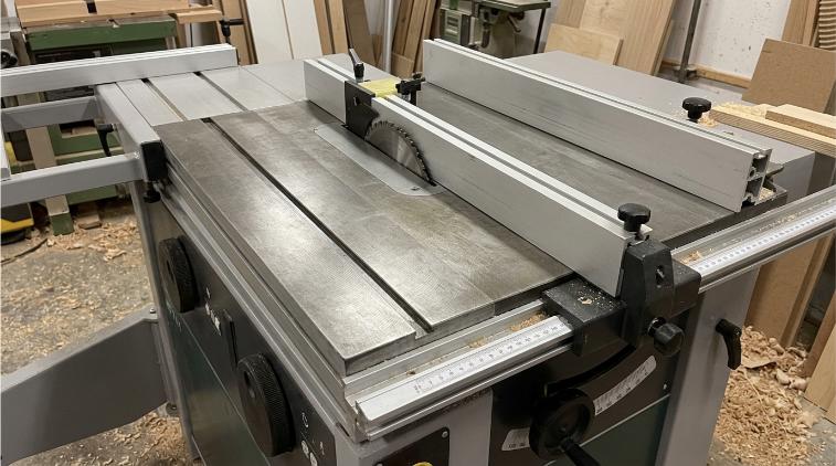 Detalle de mesa de hierro fundido en combinada de madera profesional con guía de corte